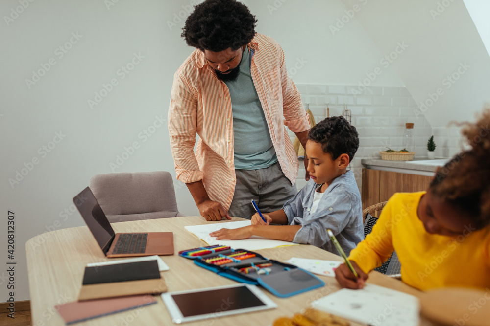 Father helping his children with their homework Father helping his children with their homework