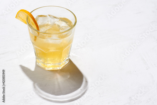 Minimalistic photo glass of alcoholic or non alcoholic kombucha with lemon slice  on a concrete background.