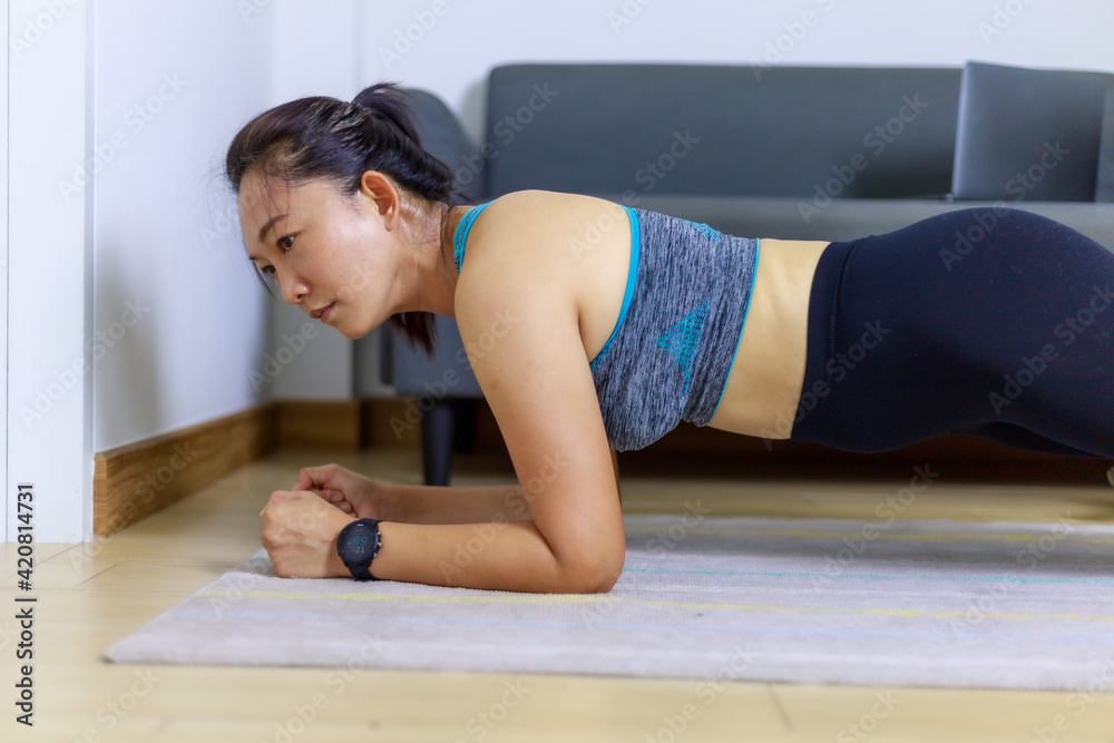 Portrait beautiful adult (40 years old) Asian woman doing Home Workout in Sports Clothing with Stretching Exercise in the room white background. Portrait beautiful adult (40 years old) Asian woman doing Home Workout in Sports Clothing with Stretching Exercise in the room white background.