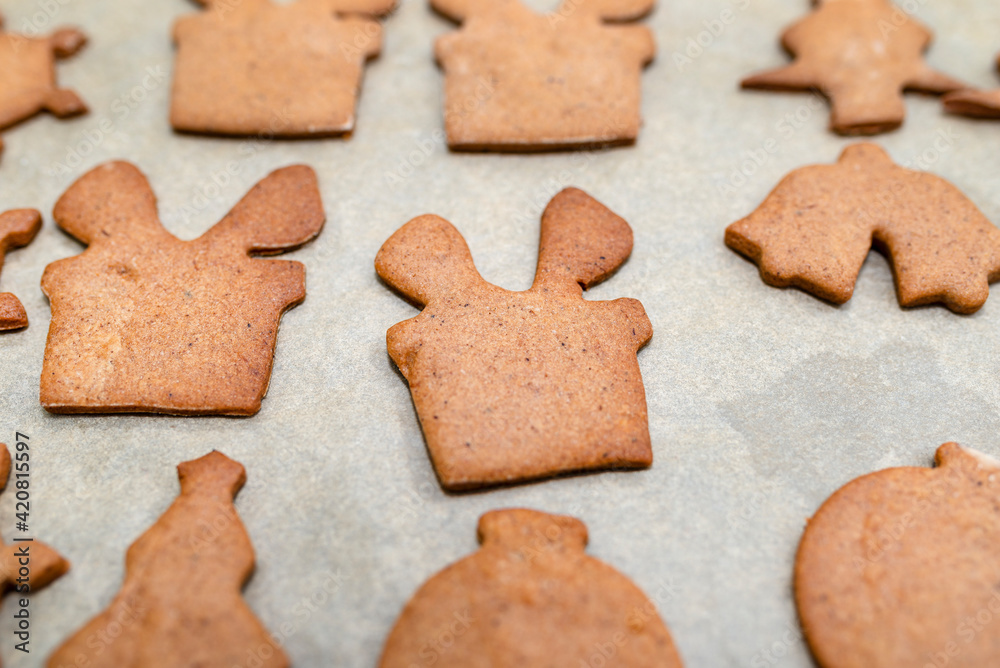 Baked gingerbread cookies in various shapes without decorations, lying on baking paper. Baked gingerbread cookies in various shapes without decorations, lying on baking paper.