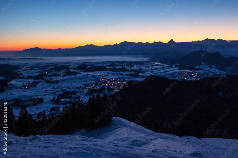 Sonnenaufgang im Winter vom Ammergebirge ,Nebel über dem Forgensee 
