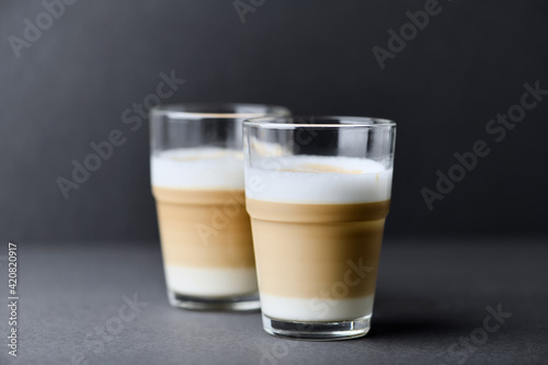 Two Glasses Of Coffee with milk on gray background. Close up. Copy space. 