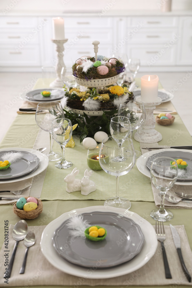 Fototapeta premium Beautiful Easter table setting with burning candles indoors