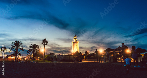 Lighthouse in the old part of the Malaga harbor at dusk