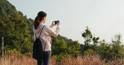 Woman use cellphone to take photo at forest