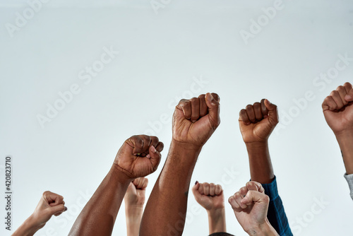 Raised hands of multiracial people clenched into fists photo