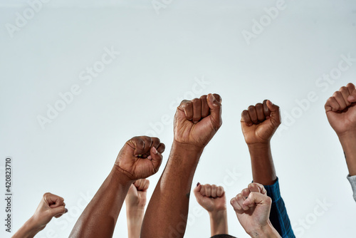 Raised hands of multiracial people clenched into fists