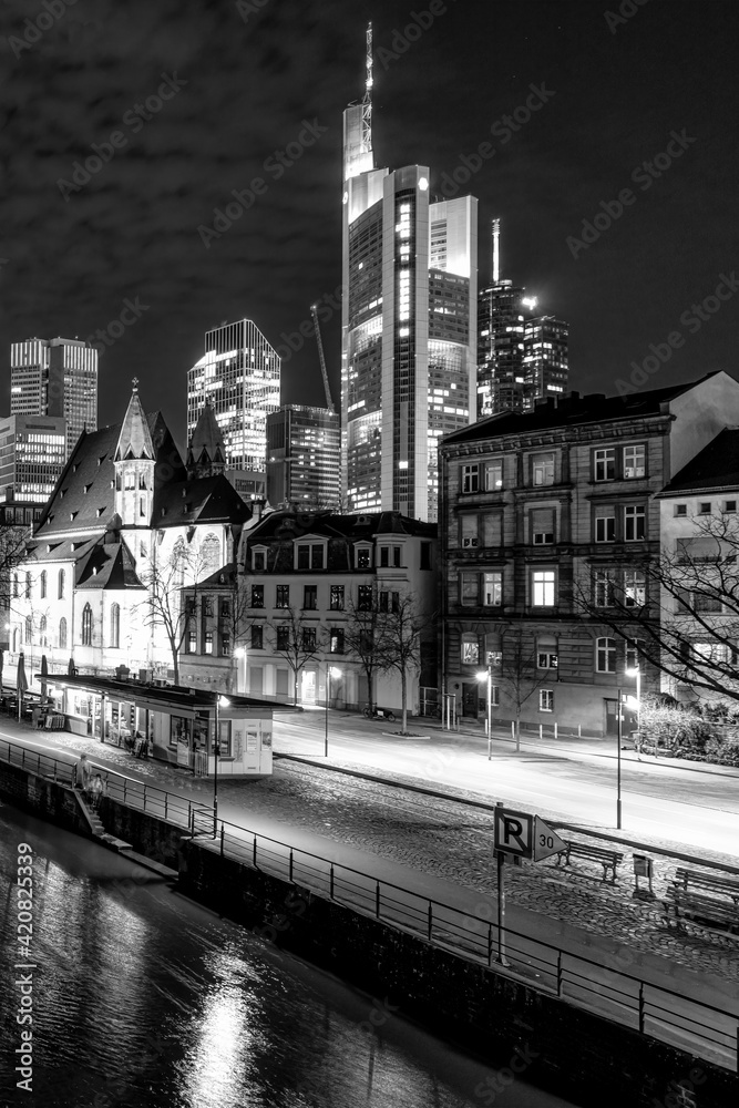 Night view from the Eisenerner Steg bridge to the illuminated cityscape of Frankfurt