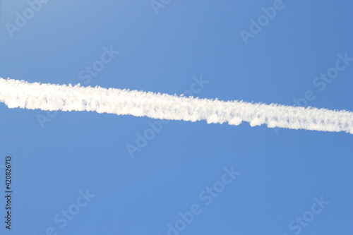 Backlit contrail with blue sky