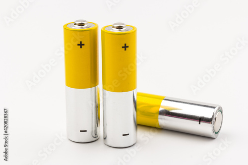 Photo of gray-yellow alkaline AA batteries on white background. Recycling of rechargeable NiMH batteries. The most popular size of accumulators. Copy space.