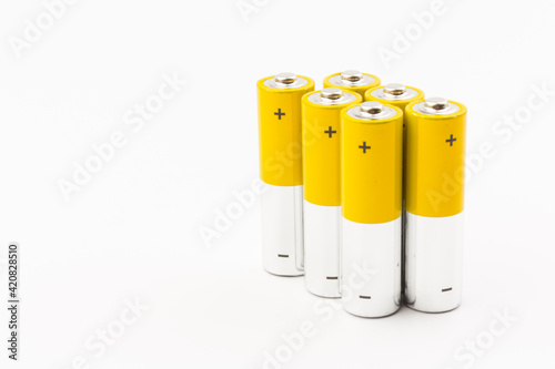 Photo of gray-yellow alkaline AA batteries on white background. Recycling of rechargeable NiMH batteries. The most popular size of accumulators. Copy space.