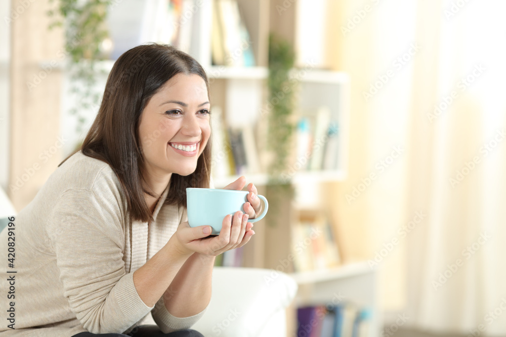 Happy woman smiling drinking coffee at home Happy woman smiling drinking coffee at home