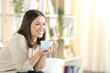 Happy woman smiling drinking coffee at home