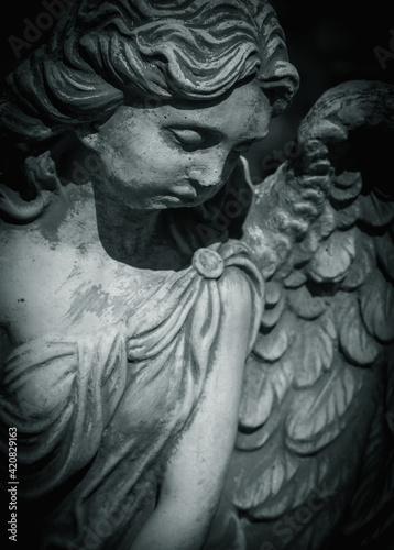 Fragment of an ancient statue of sad angel as a symbol of eternity, life and death. Religion concept.