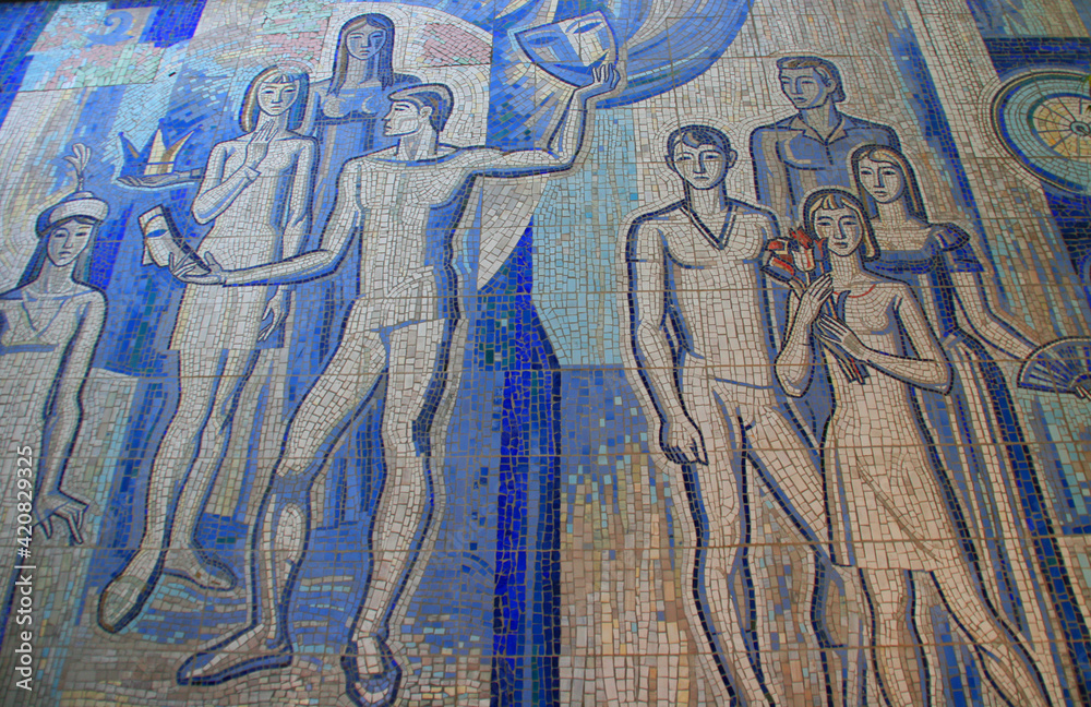 Obraz premium Osh, Kyrgyzstan - 09.09.2019: Tajikistan - Soviet mosaic closeup detail. Detail of old antique mosaic. Typical plot of street art of USSR period. Mass street culture of primitive Soviet poster. 
