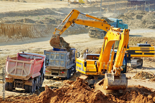 Excavation and loading onto dump trucks with excavators. The work of construction equipment in the production of earthworks