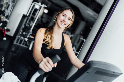 Portrait of a smiling girl on a cardio machine, healthy look, healthy body
