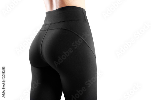 Cropped image of the back of a female model dressed in tight black leggings. Sportswear concept.