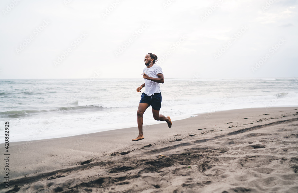 Happy black sportsman running along seashore Happy black sportsman running along seashore