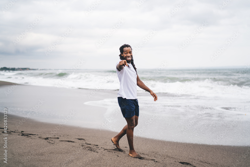 Cheerful black man walking on beach Cheerful black man walking on beach