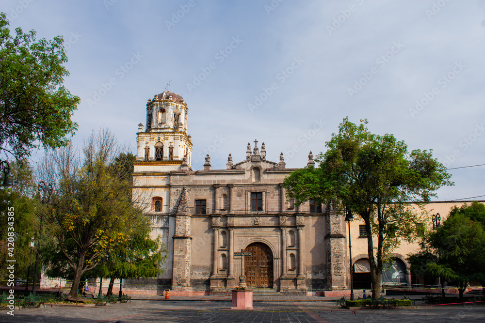 Fototapeta premium Old Mexican Church surrounded by trees in Coyoacan