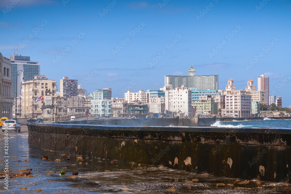 Fototapeta premium Coastal urban landscape of central Havana and towards the Vedado district, with the characteristic wall that protects the Malecon promenade, near the Antonio Maceo Park.