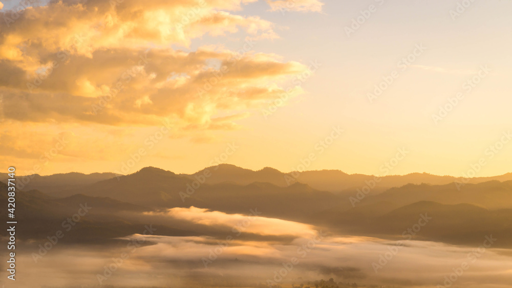 Landscape view of mountain with Sunrise golden light of dawn in fog.