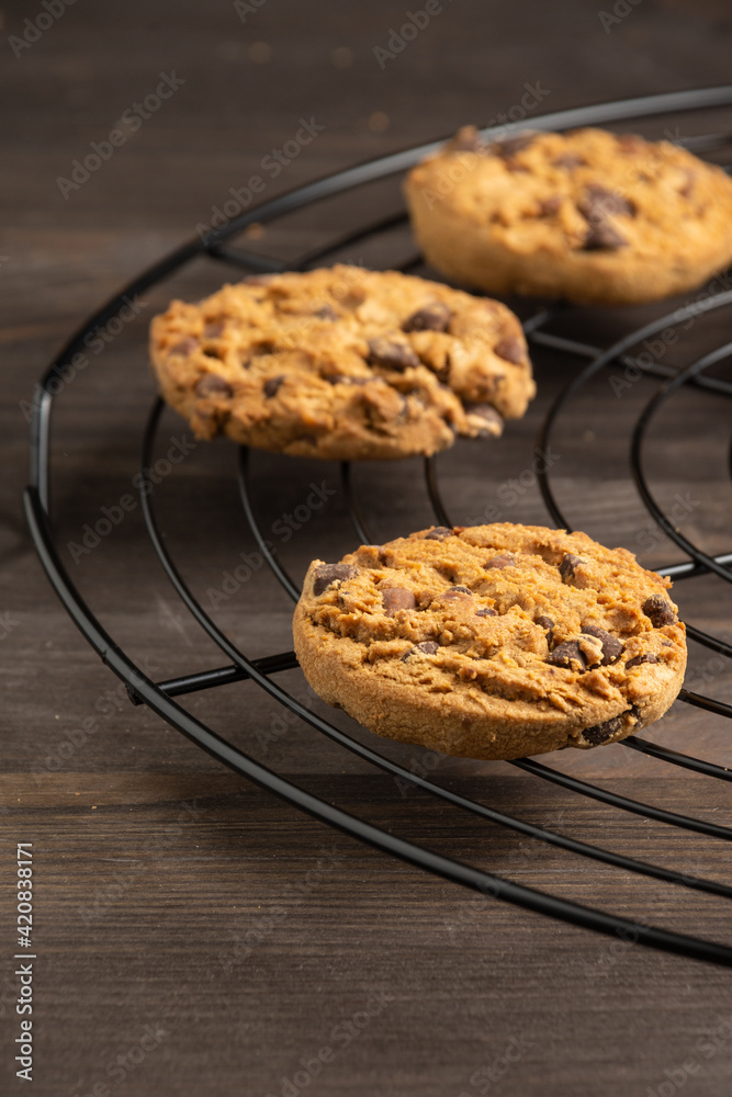 Close-up of chocolate cookies on wire rack, selective focus, on wooden table, vertical Close-up of chocolate cookies on wire rack, selective focus, on wooden table, vertical