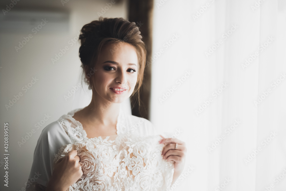 Beautiful bride wearing fashion wedding dress with feathers with luxury delight make-up and hairstyle, studio indoor photo shoot Beautiful bride wearing fashion wedding dress with feathers with luxury delight make-up and hairstyle, studio indoor photo shoot