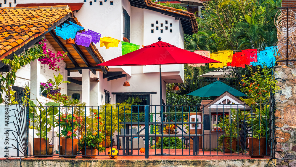 Fototapeta premium Family vacation home with colorful parasols, sun umbrellas, children's play toys, tropical climate and terraced homes – background.