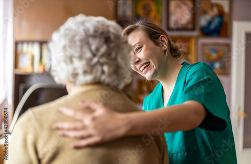 Friendly nurse supporting an elderly lady
