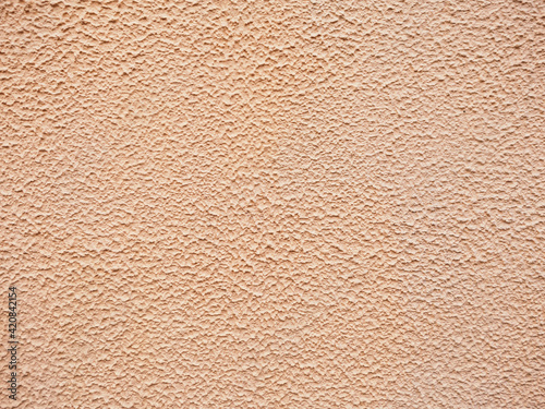 Close up painted golden concrete wall stucco texture background pattern, exterior outside house appartment living room decoration. Empty free copy space for text or message. 