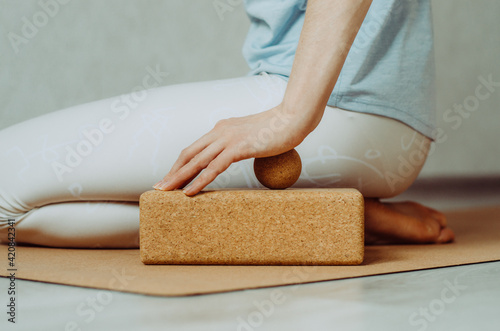 Side view of person doing palmar fascia release with a small cork ball on a cork block 