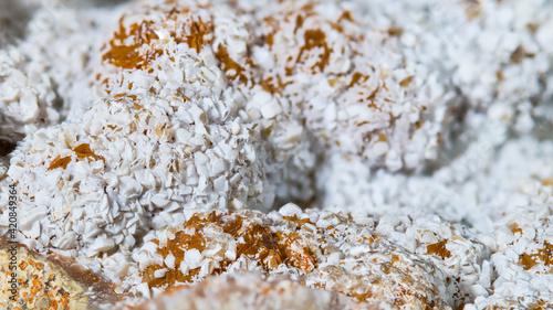 White and orange clusters of crystals on aragonite mineral in texture detail. Close-up of calcium carbonate crystal form. Mineralogy. Collectable item from Hridelec near Nova Paka, north-east Czechia.