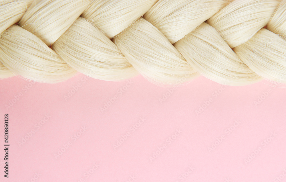 Smooth white beautiful pigtail. The braid is braided by a blonde on a pink background. The concept of hairdressing, hair purchase, hair health, hair extensions. Top view. Flatlay.Copyspace. - obrazy, fototapety, plakaty 