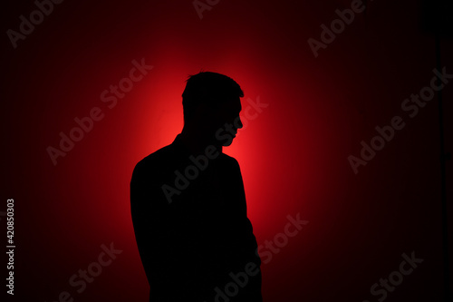 Silhouette of a man on a red background.