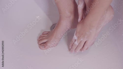 Woman washes feet with soap. Hygiene and health care concept.