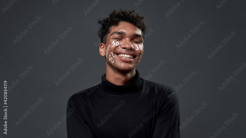 Portrait of happy young boy with percents on face