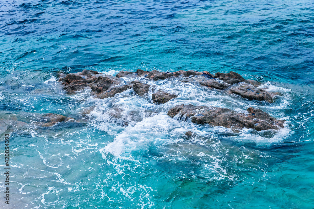 Obraz premium blue sea and waves breaking over the rocks. blue seascape