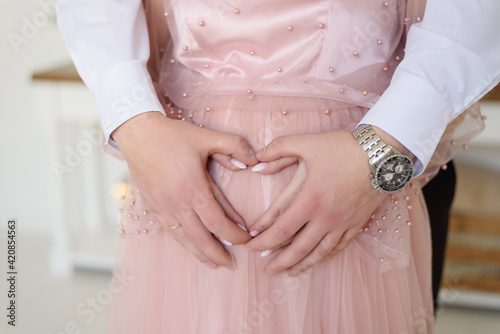 Waiting for the baby. Male and female hands on the stomach.