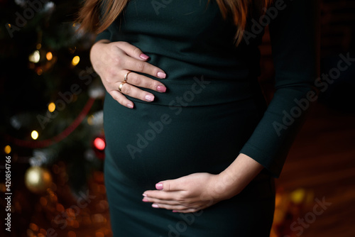 Waiting for a baby. The woman hands are on her stomach.
