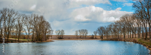 pond in early spring Reflection of reeds, sky and trees in the water . Peace ...