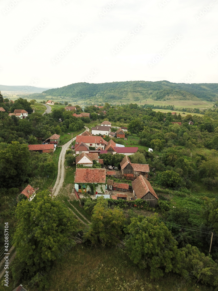 Aerial drone vertical panorama above a rural settlement located in a hilly region in Transylvania. Summer season, Romania.