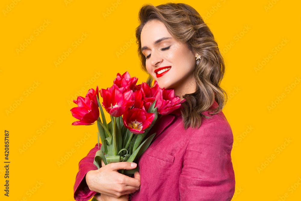 Close up portrait of a young beautiful woman holding some magenta tulips near her face. Close up portrait of a young beautiful woman holding some magenta tulips near her face.