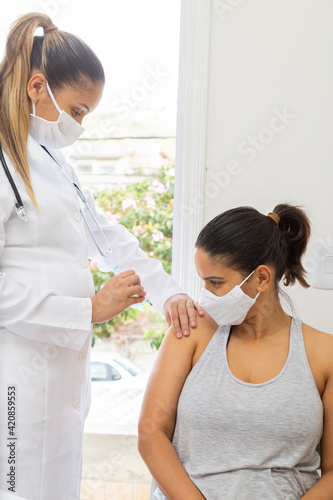 Patient seeing doctor applying vaccine to arm. Wide sight. Vertical photo.