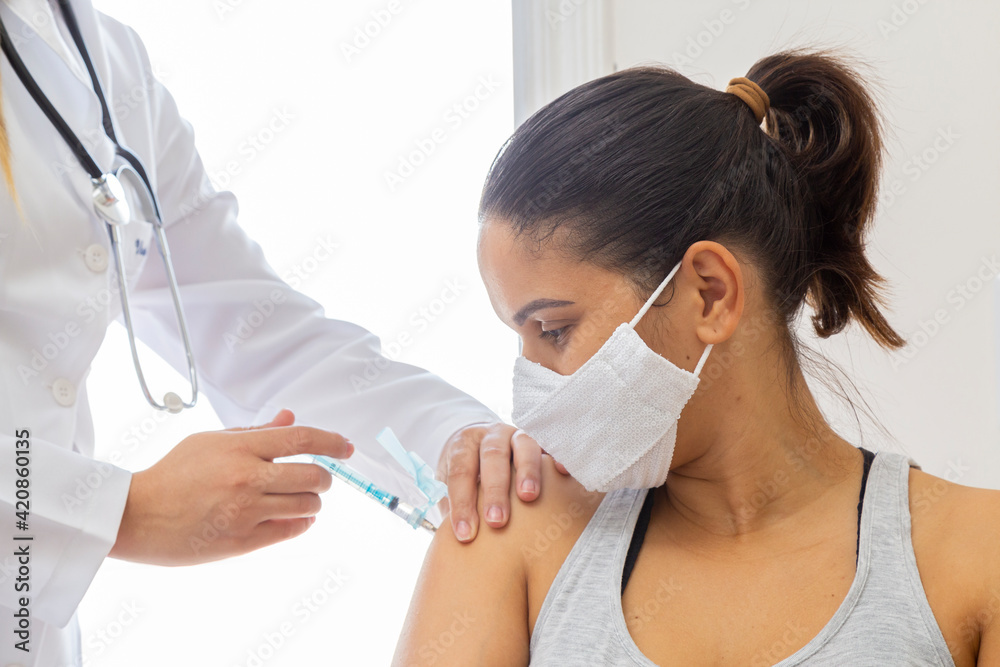 Female doctor holding mask on patient's shoulder. Close up