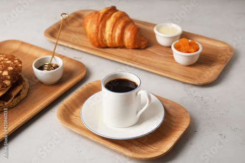 Fototapeta Naklejka Na Ścianę i Meble -  Wooden trays with tasty breakfast on light background