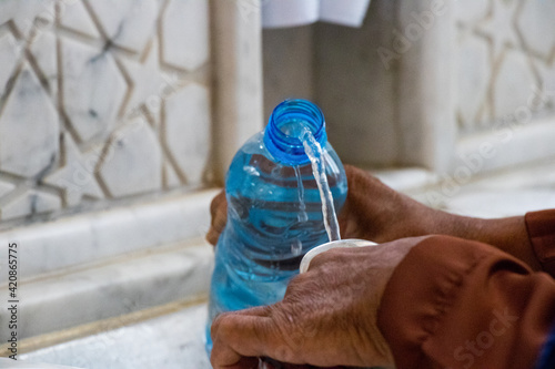 Filling zamzam water into the bottle. Zamzam well in Masjid-Haram. Water photo