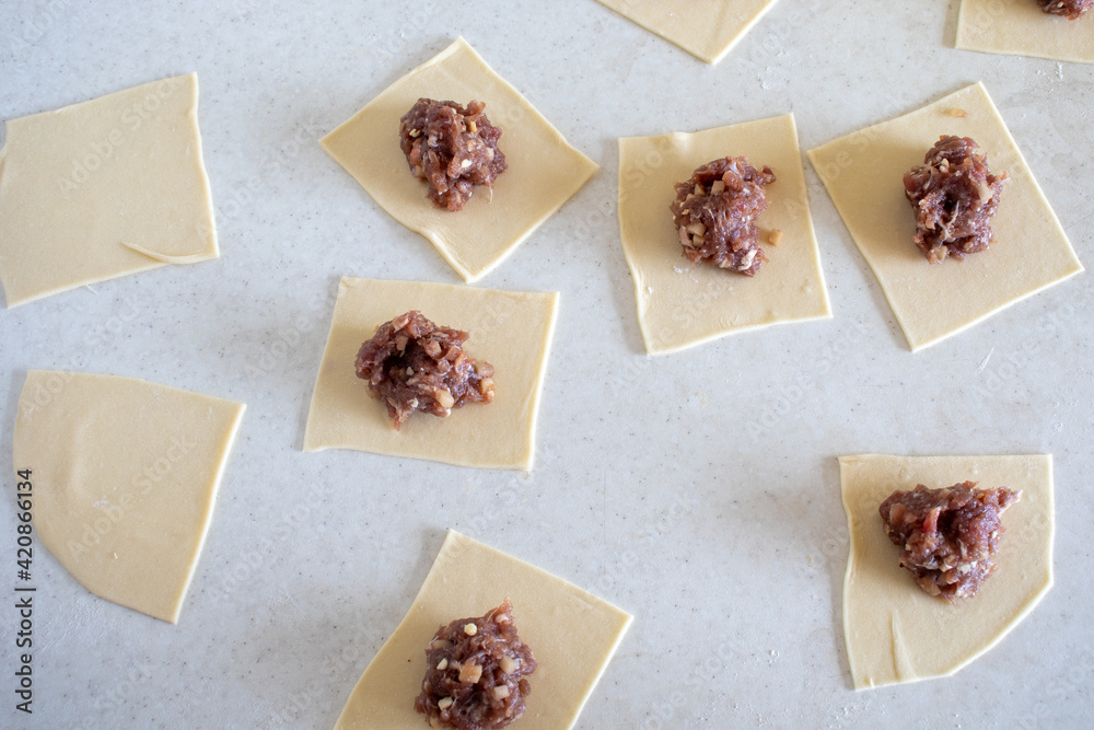 Raw Manti with meat inside (dumpling). Raw meat in the dough. Raw meat in dough on the table Raw Manti with meat inside (dumpling). Raw meat in the dough. Raw meat in dough on the table