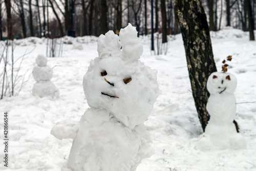 Scary snowmen are standing in the park